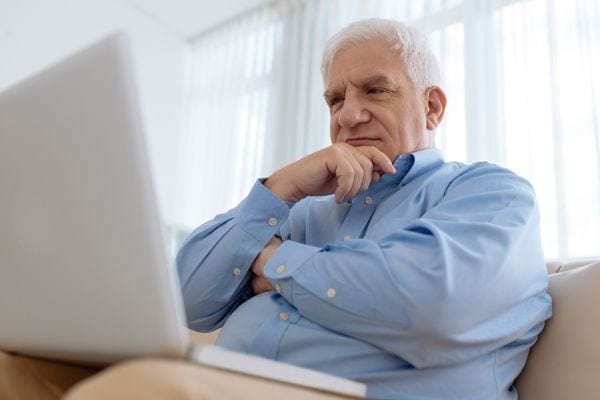 A man ponders on a laptop. Why Is My Furnace Filter Soggy?
