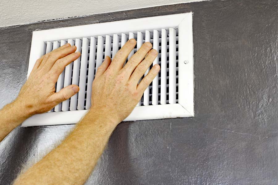 Why Is My AC Blowing Hot Air? Hands at vent.