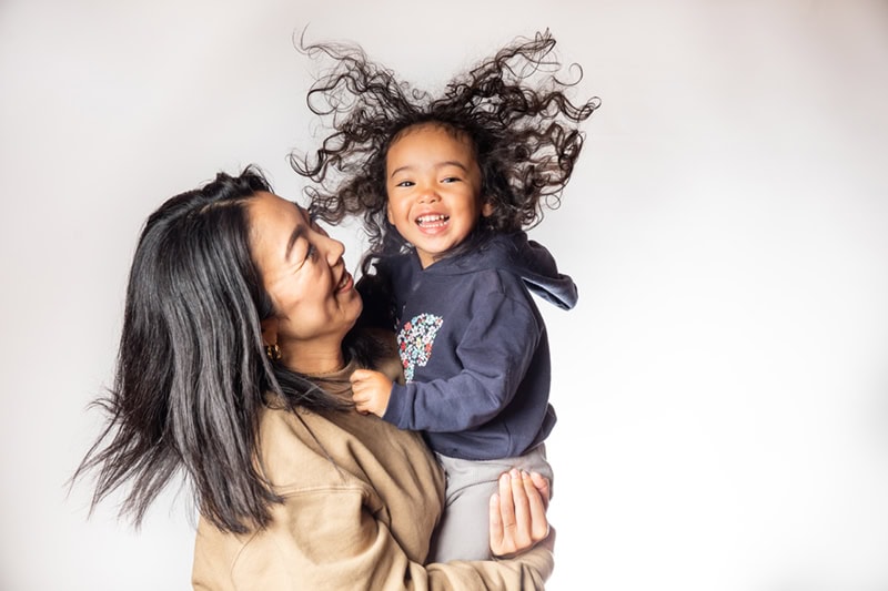 Mother holding her child who has static hair.